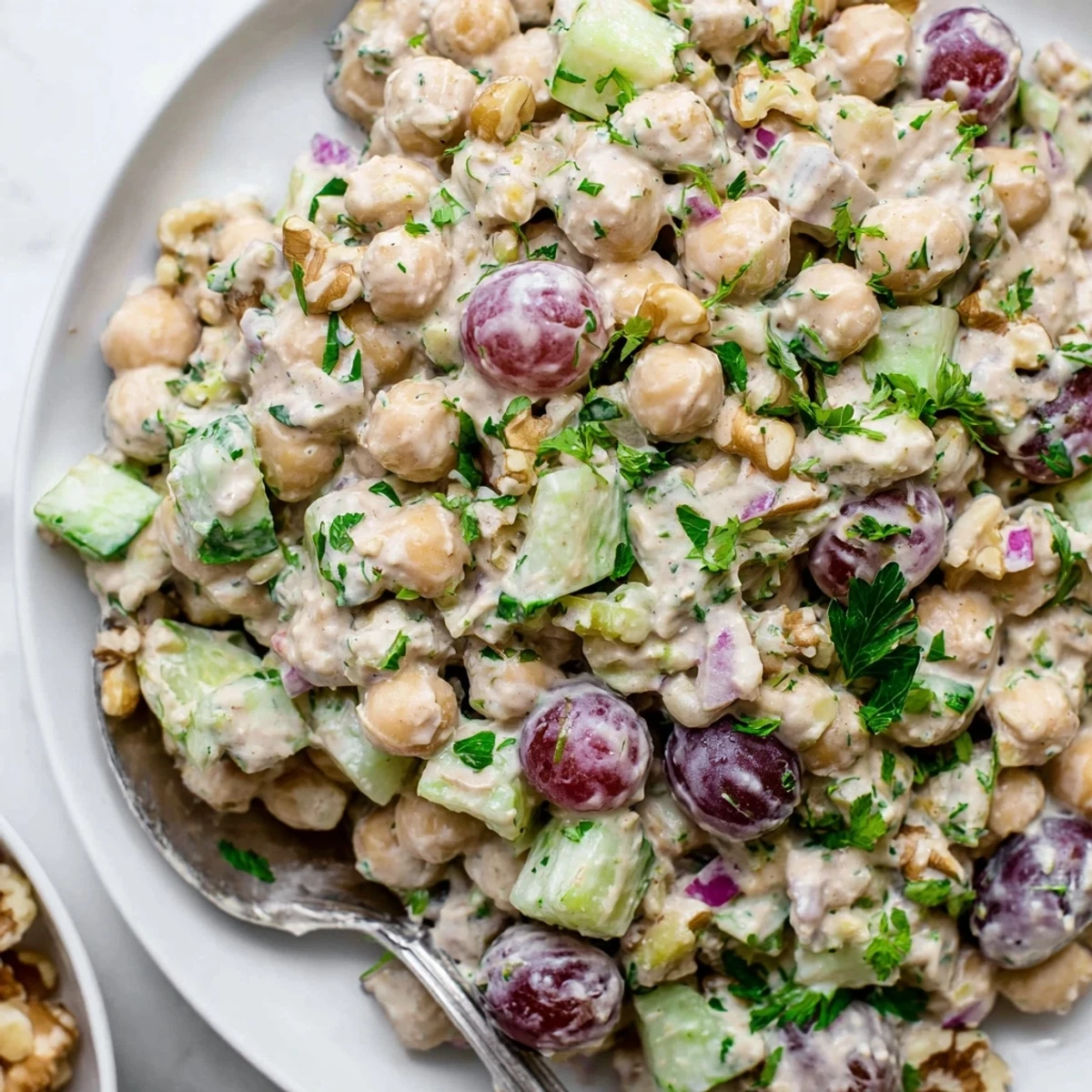 Creamy vegan chicken salad piled on toasted whole grain bread with fresh herbs