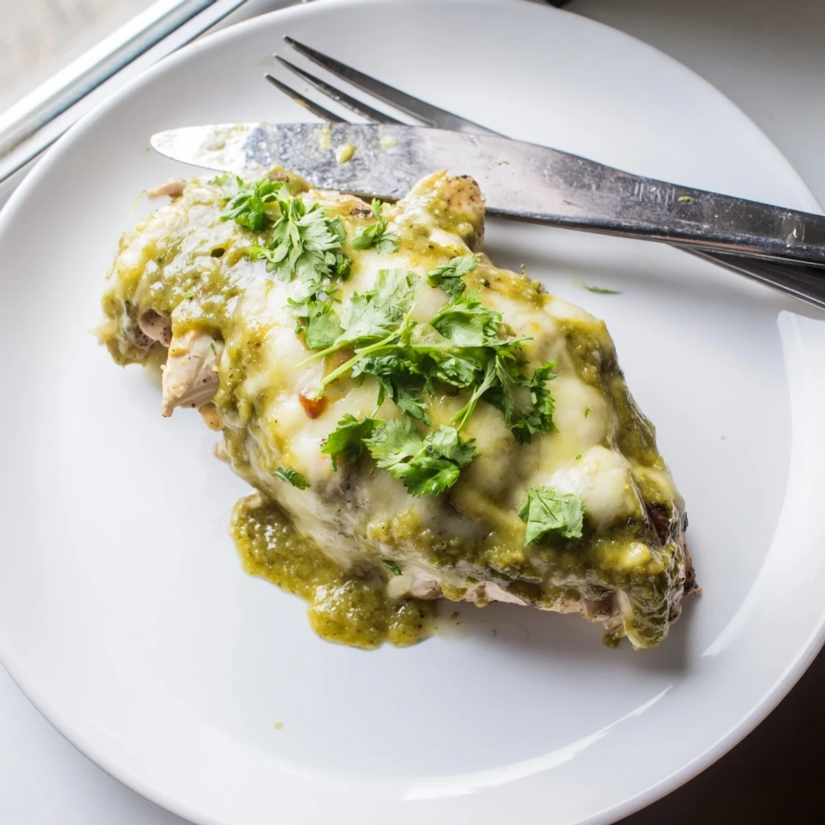 Golden Cheesy Grilled Salsa Verde Pepper Jack Chicken with bubbling melted cheese on a rustic platter