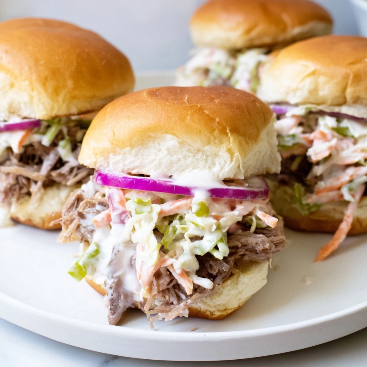 Juicy Alabama white sauce pulled lamb sliders topped with crunchy slaw on toasted buns