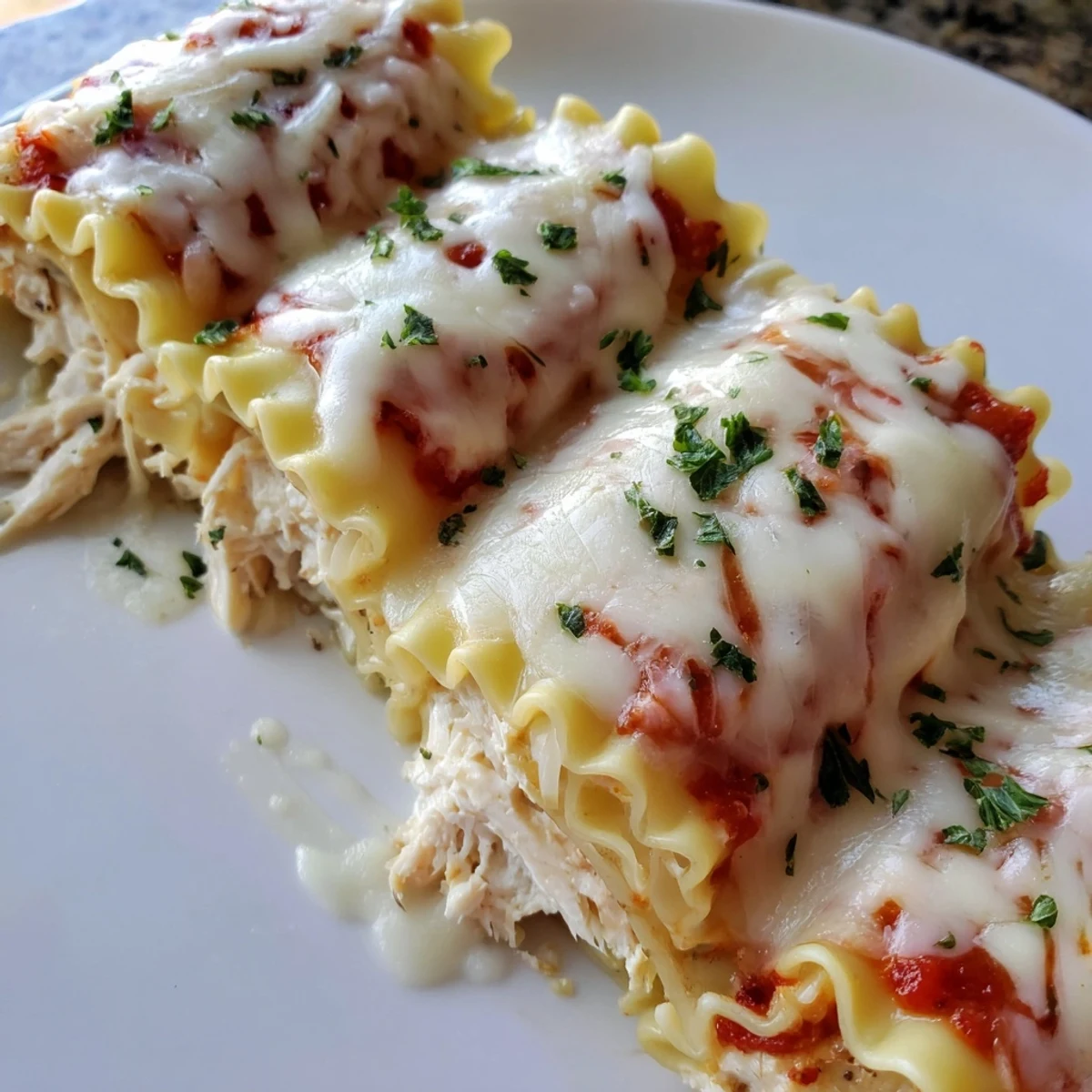 Garlic Parmesan Chicken Lasagna Roll Ups bubbling with golden melted mozzarella in a creamy white sauce