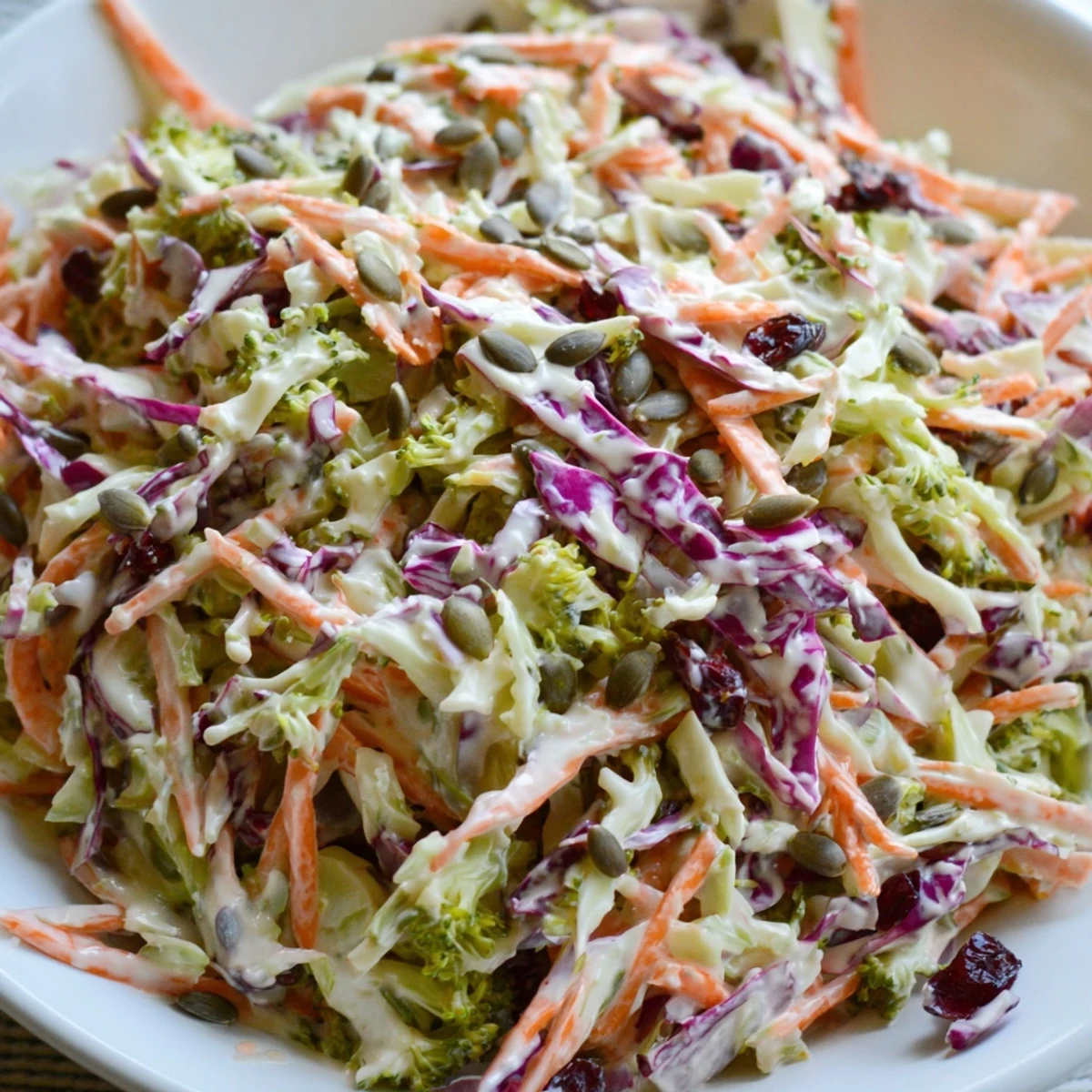 Crunchy broccoli slaw topped with dried cranberries, served fresh on a picnic table