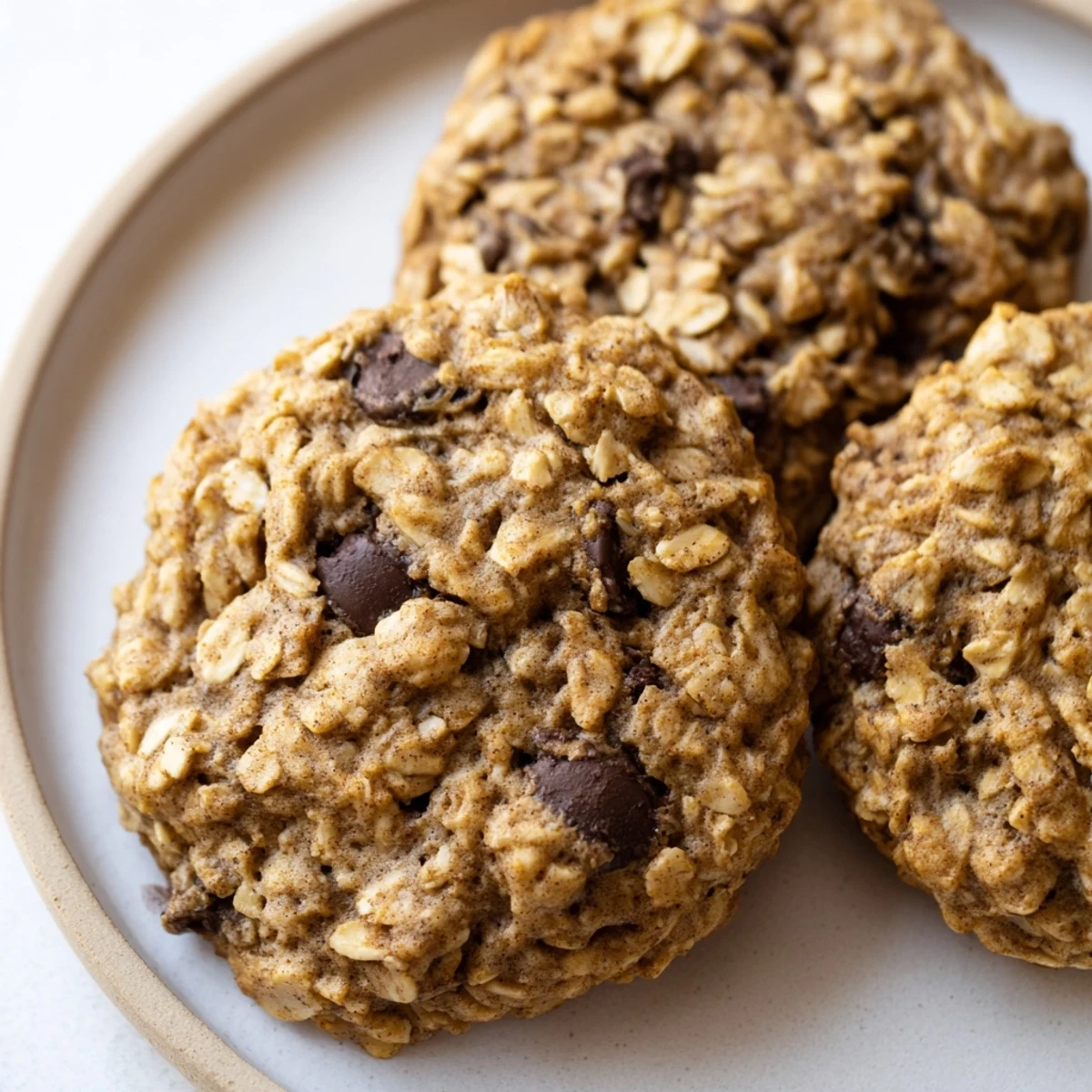 Golden chewy banana oatmeal cookies fresh from the oven on a parchment-lined baking sheet.