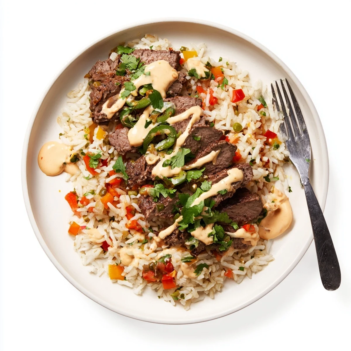 Creamy steak queso rice piled high in a rustic bowl with melted cheese drizzle