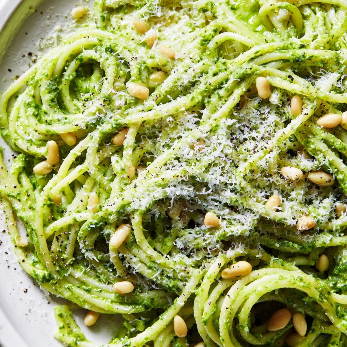 Wild garlic pesto pasta twirled on a fork with glossy, fragrant basil-green coating