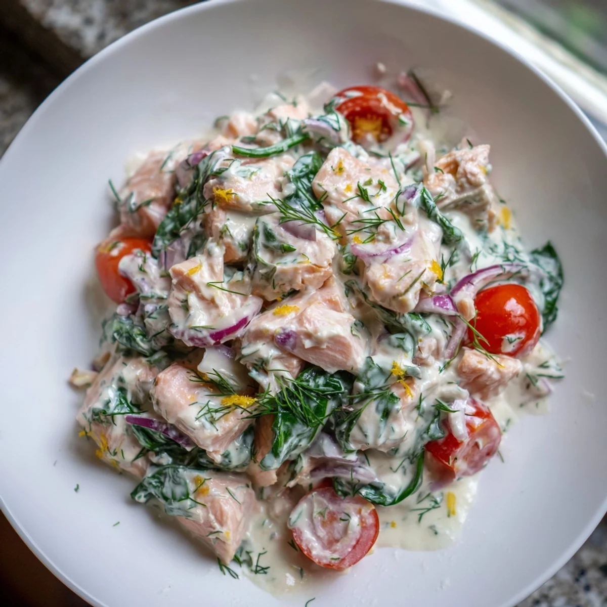 Healthy creamy leftover salmon recipe topped with chives and served in a rustic white bowl