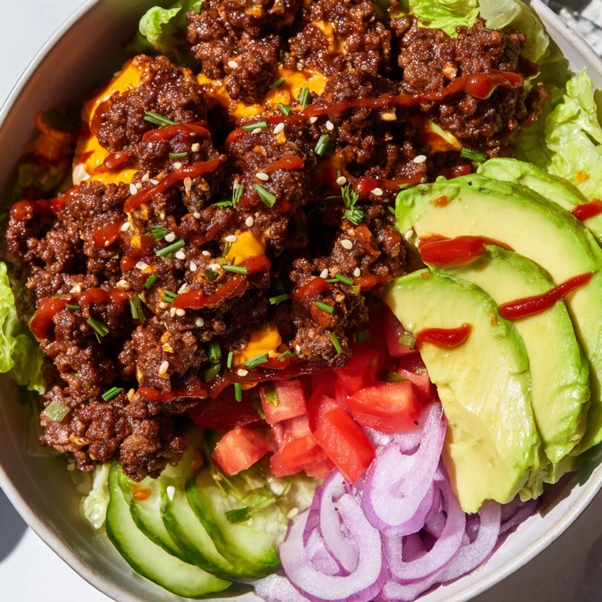Colorful burger bowls loaded with seasoned ground beef, fresh veggies, and melted cheddar cheese