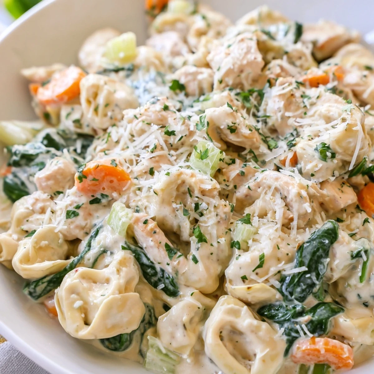 Creamy Crockpot Chicken Tortellini served in a rustic bowl with fresh parsley garnish