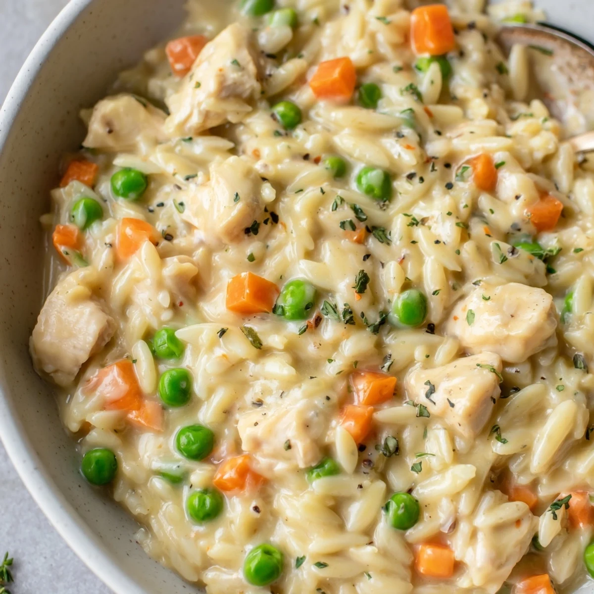 A deep skillet filled with Creamy Chicken Pot Pie Orzo and fresh parsley.