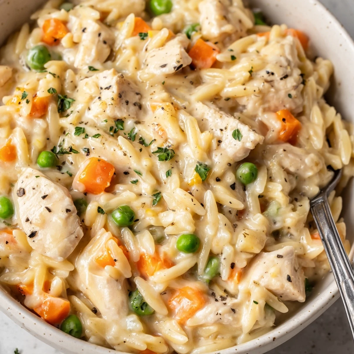 Scooping up a thick, saucy portion of Creamy Chicken Pot Pie Orzo.