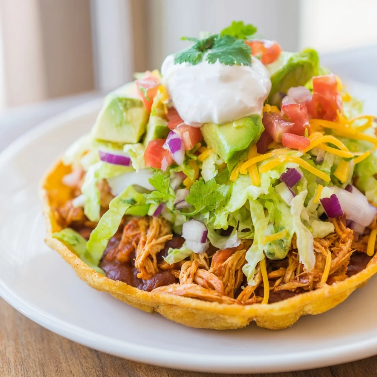 Crispy Chicken Tostadas topped with fresh veggies and creamy cheese for a delicious meal.  