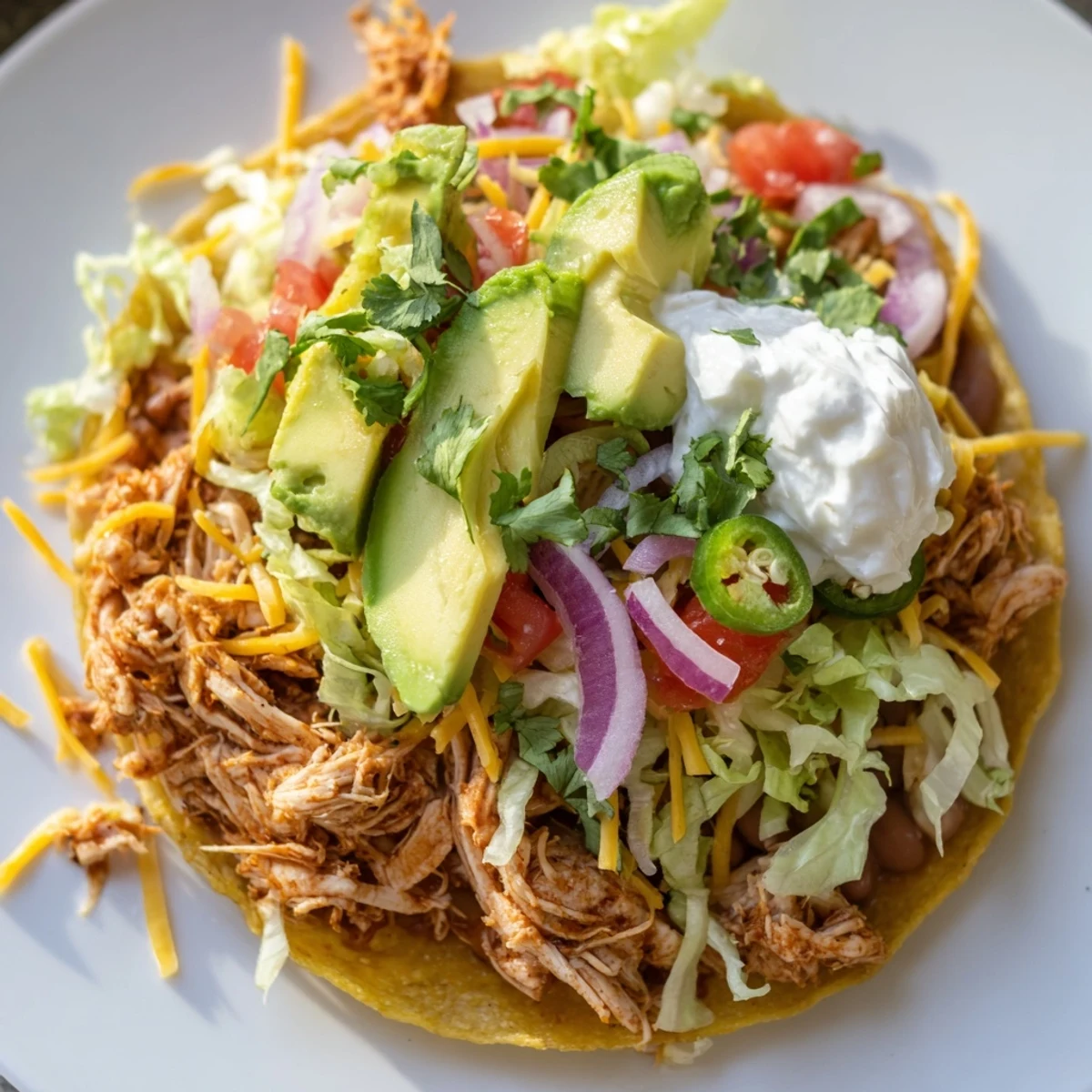 Delicious chicken tostadas topped with vibrant tomatoes, red onion, and spicy jalapeños.