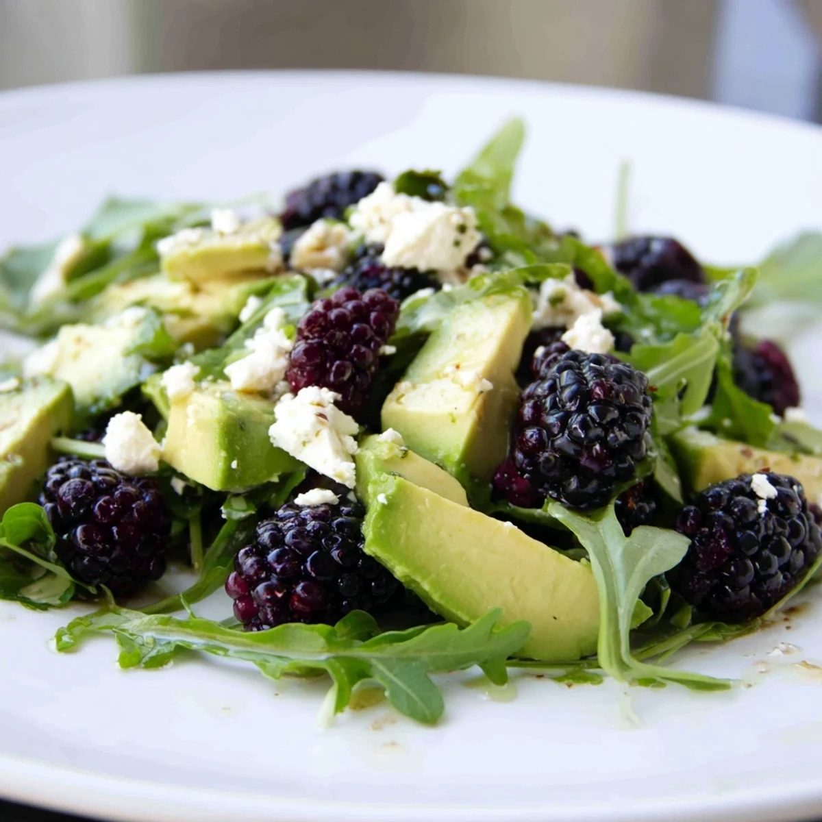Vibrant blackberry avocado salad bowl topped with sweet blackberries, sliced red onion, and zesty lime dressing  