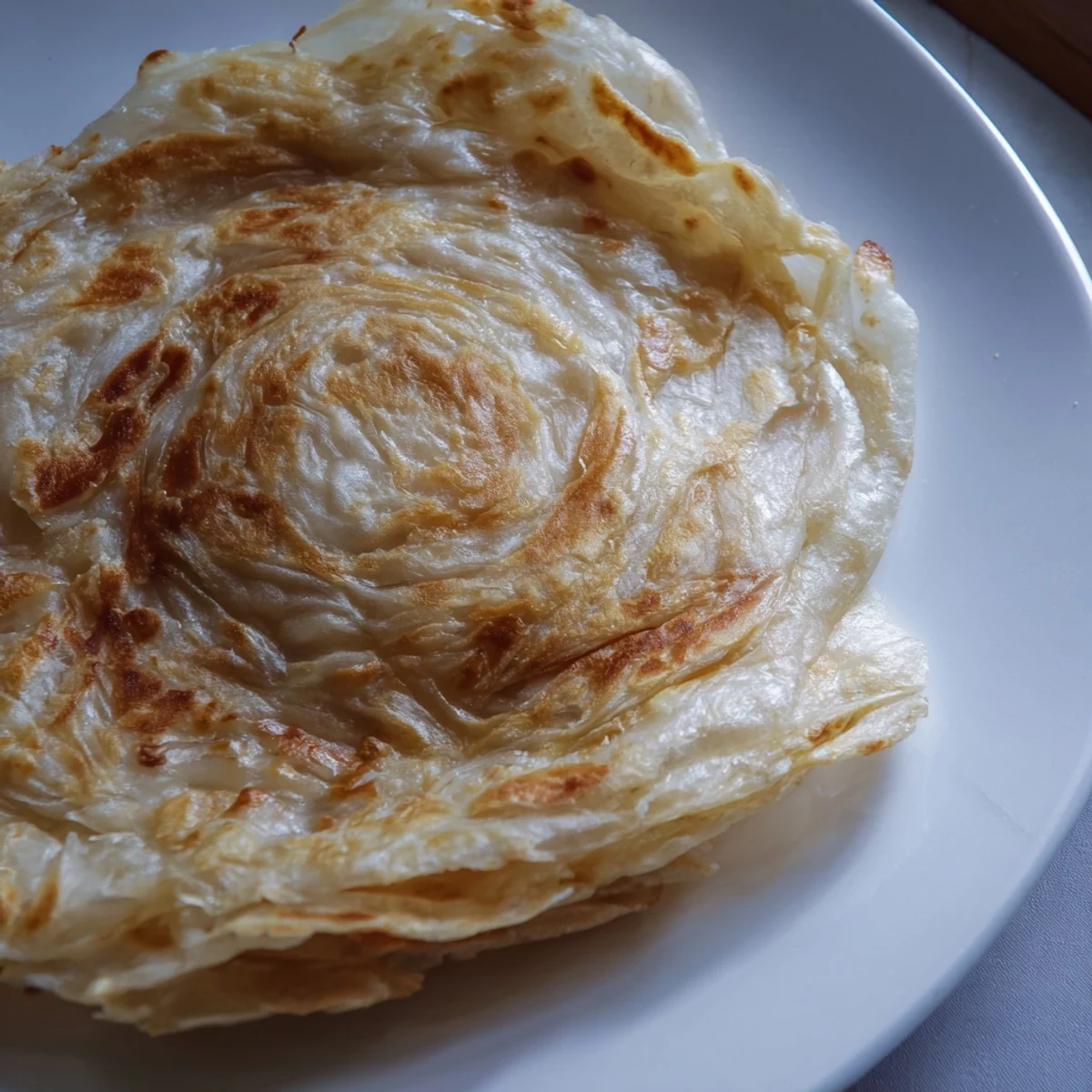 Hand-stretched roti canai pan-fried to golden crispness and folded into delicate layers.  