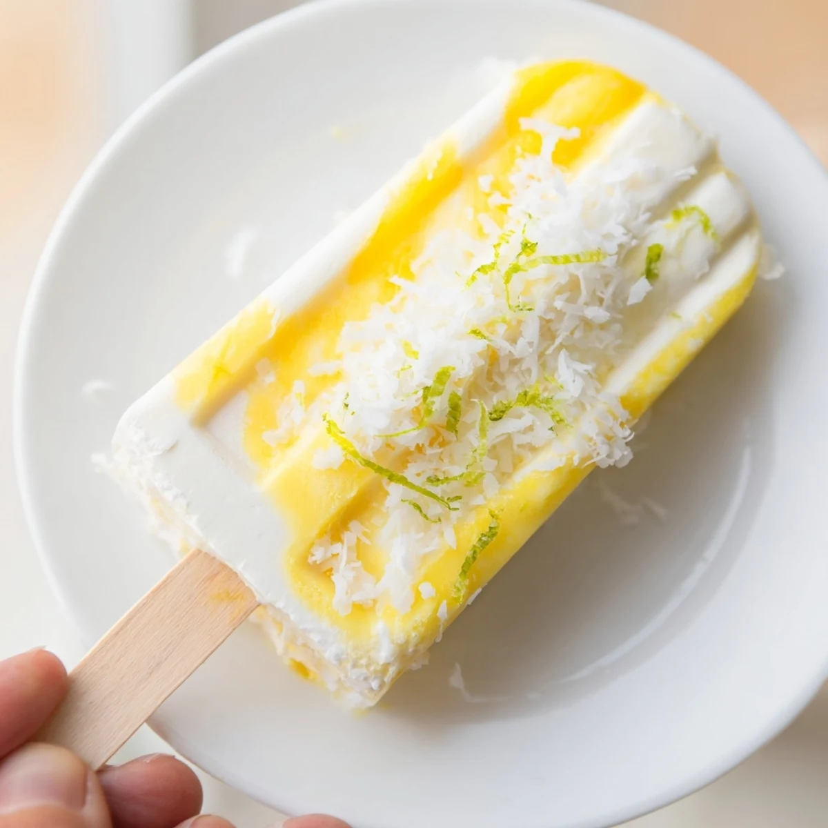 Creamy pineapple coconut lime popsicles swirling with fresh tropical fruit flavors on a stick  