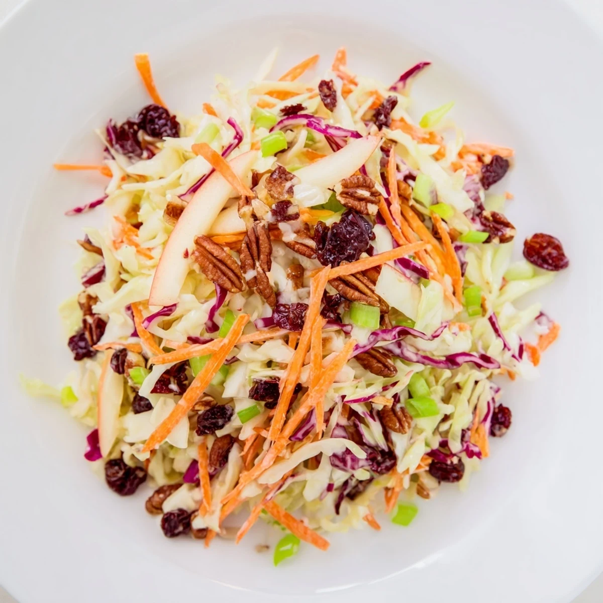Vibrant cranberry apple coleslaw with crunchy cabbage and sweet apple slices.