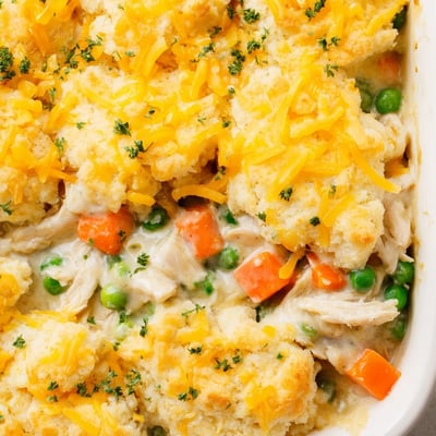 A close-up of Red Lobster Biscuit Chicken Pot Pie reveals bubbling, savory filling beneath buttery, garlic-herb brushed biscuits, ready for a cozy family dinner.  