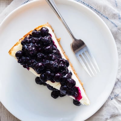 Rich blueberry cheesecake recipe with graham cracker crust and sweet berry swirl.